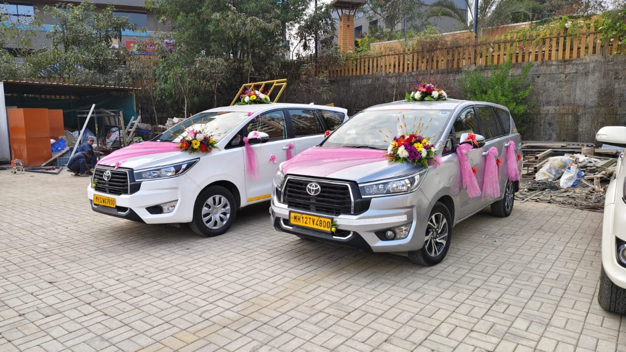Two Om Travels Innova Crysta cars decorated with flowers for a wedding