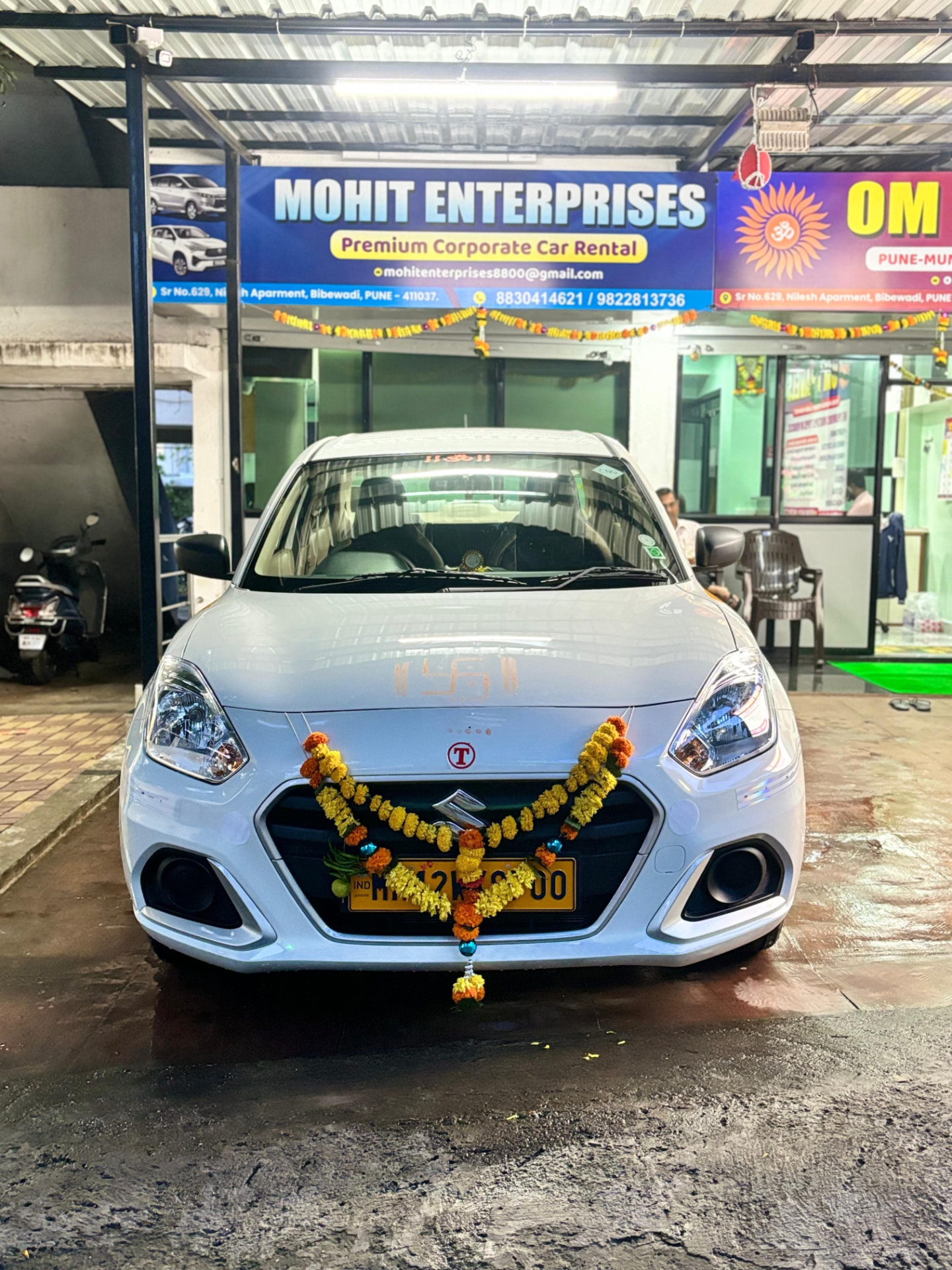 New Dzire with marigold garland outside the Om Travels office